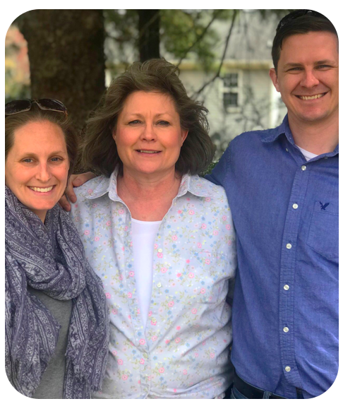 Dawn Simpson stands between a young adult man and a young adult woman.