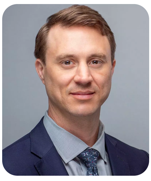 A head shot of Matt Moser wearing a suit and tie.